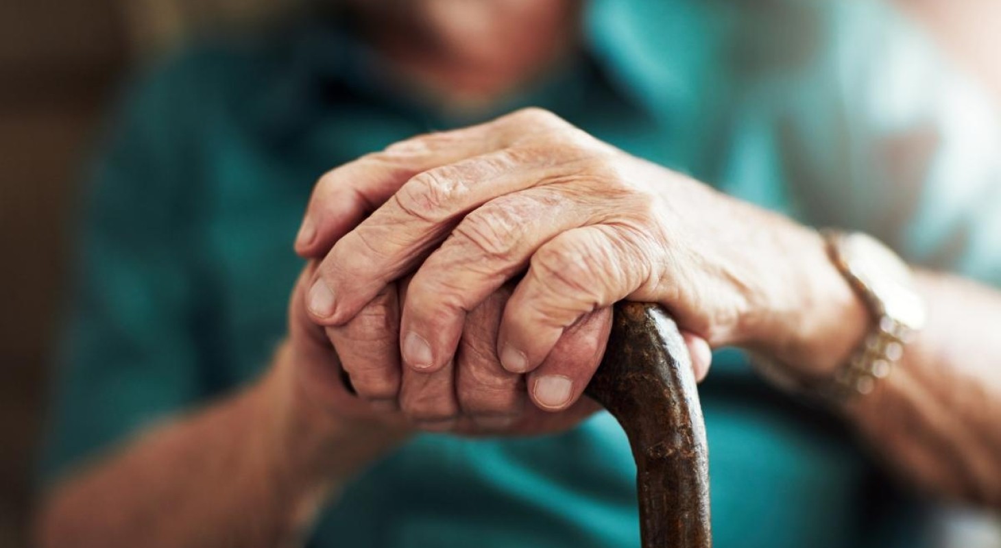 close up of elderly gentlemans hands on cane