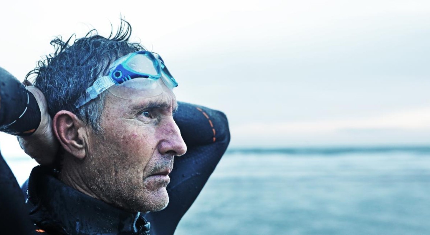 retired man gazing at ocean after a swim