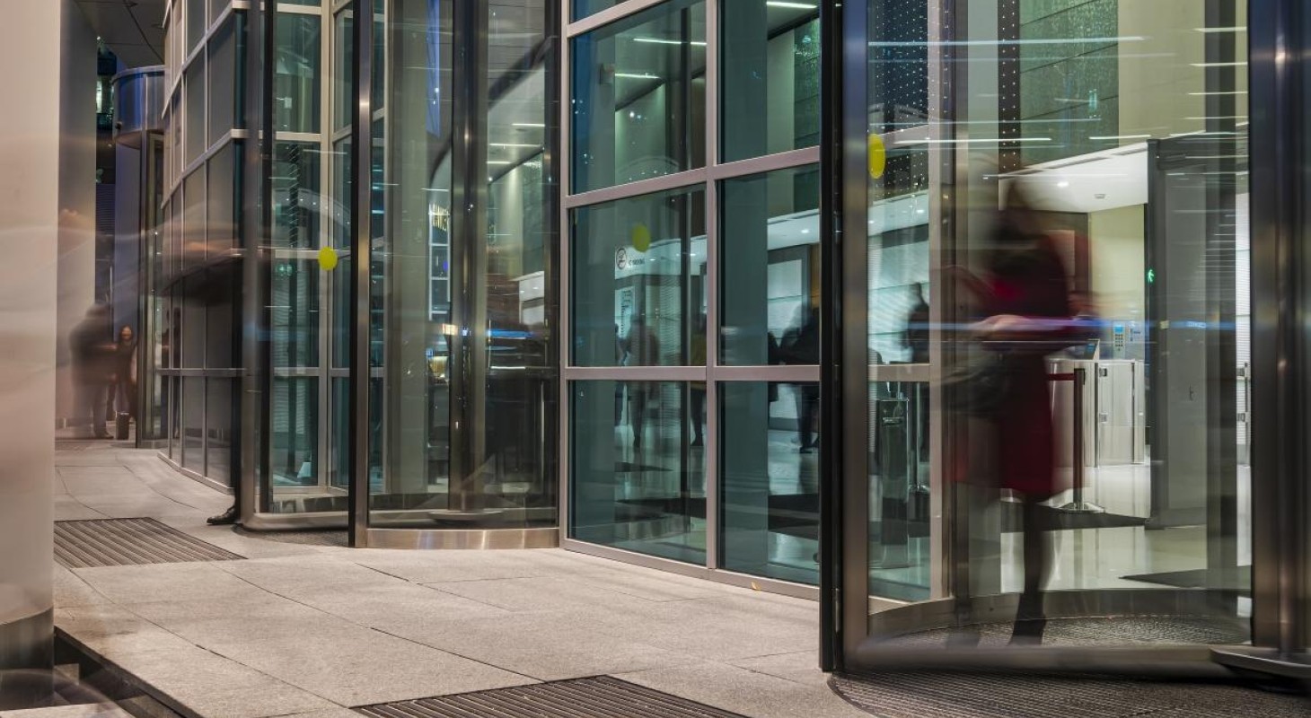 blurred image of people moving through revolving office door