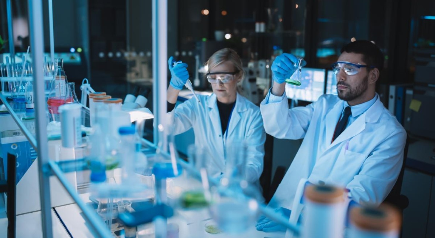 female and male researchers in lab under blue light