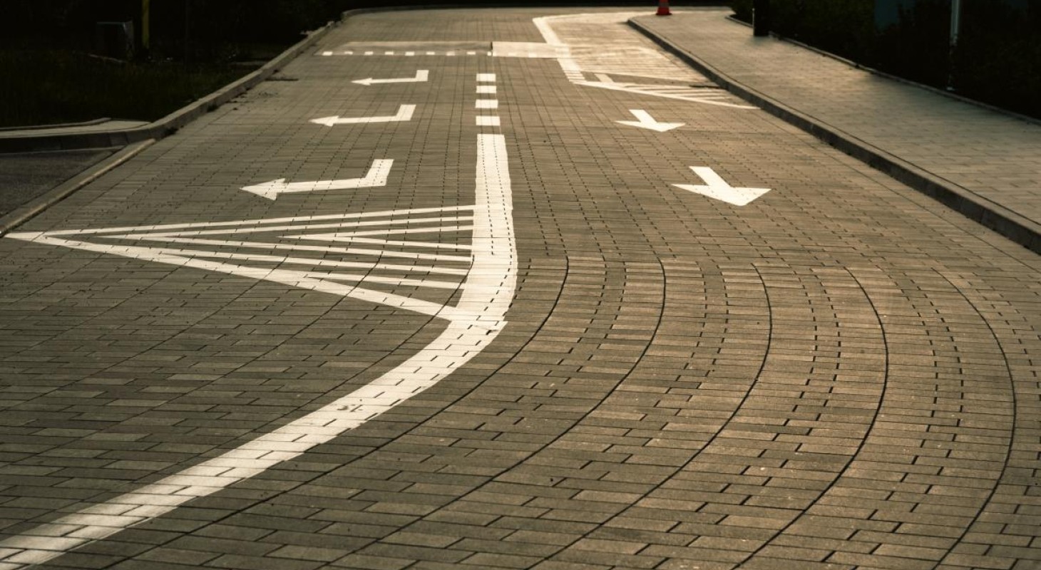 asphalt road with white directional markings for straight and right turn