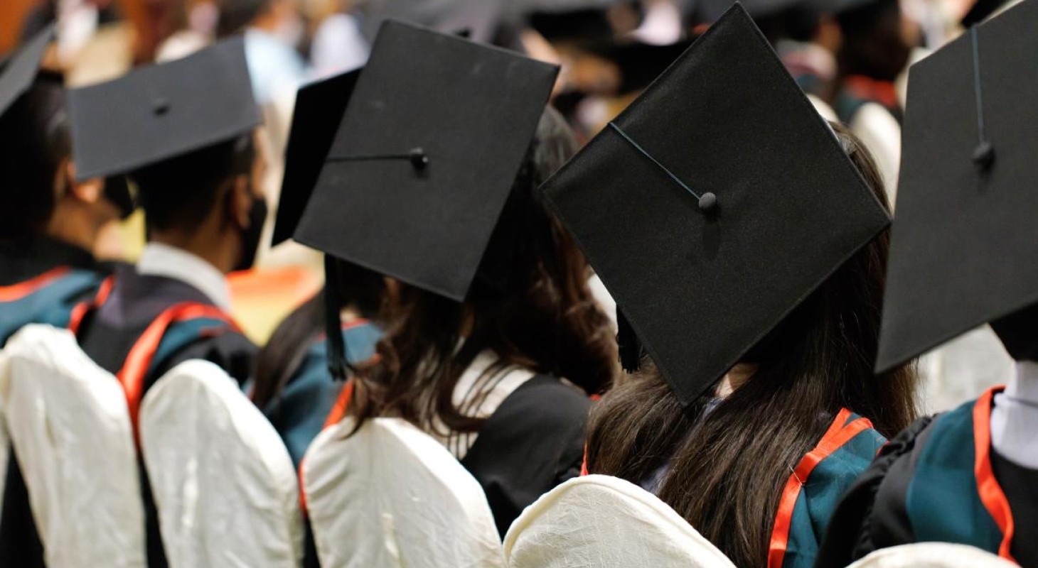 row of college graduates with caps and gowns