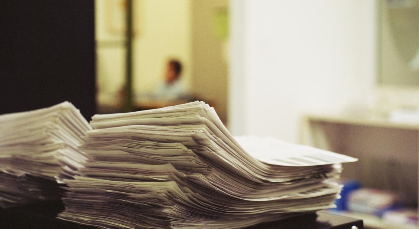 stack of paperwork on top of black cabinet