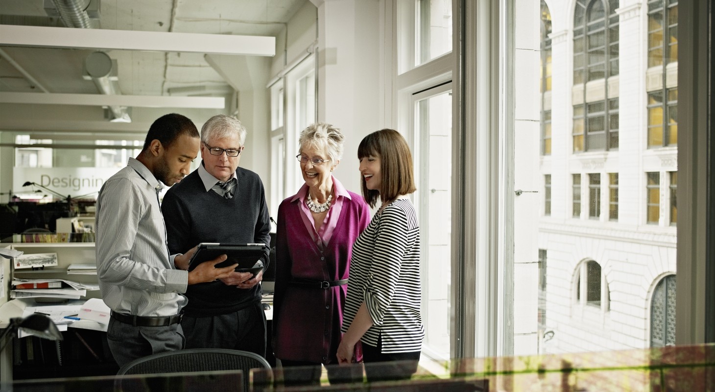 coworkers discussing project on digital tablet