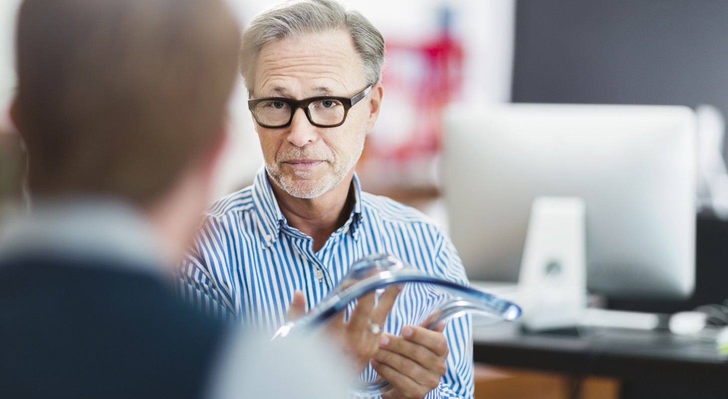 businessman explaining glass model to colleague