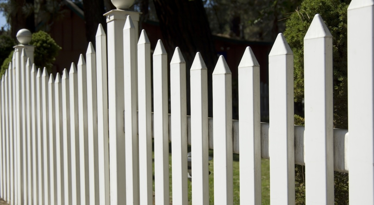 tall white picket fence in suburban yard