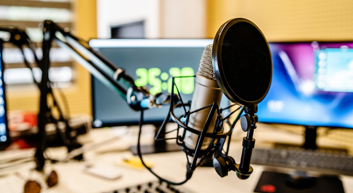 podcast microphone and sound mixer in front of monitors