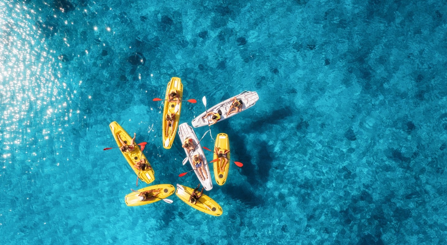 aerial view of seven kayaks on clear blue water