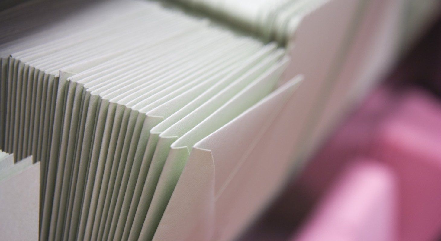 stacked envelopes on pink shelf