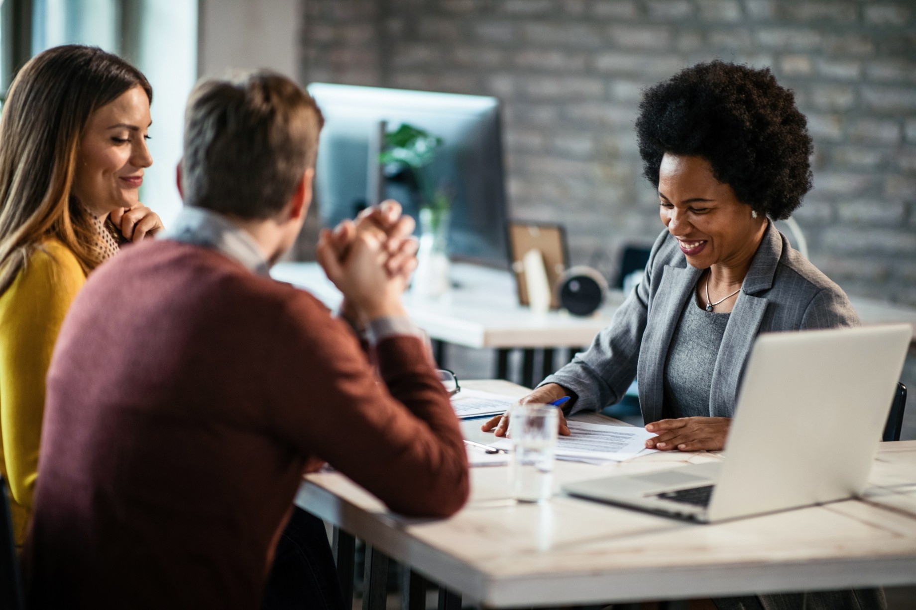 cheerful african american financial advisor in a meeting with a couple