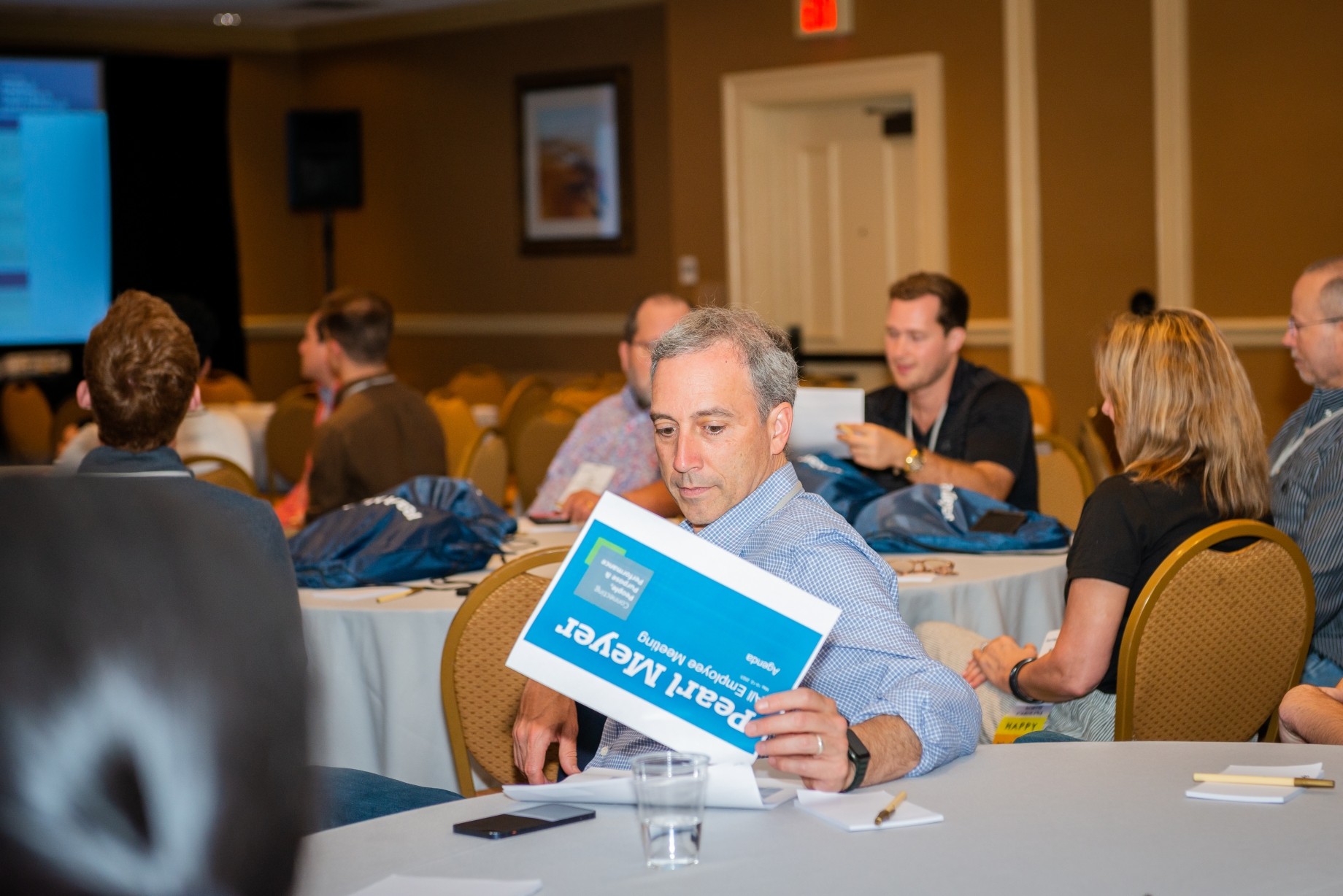 Man at meeting looking at work file 