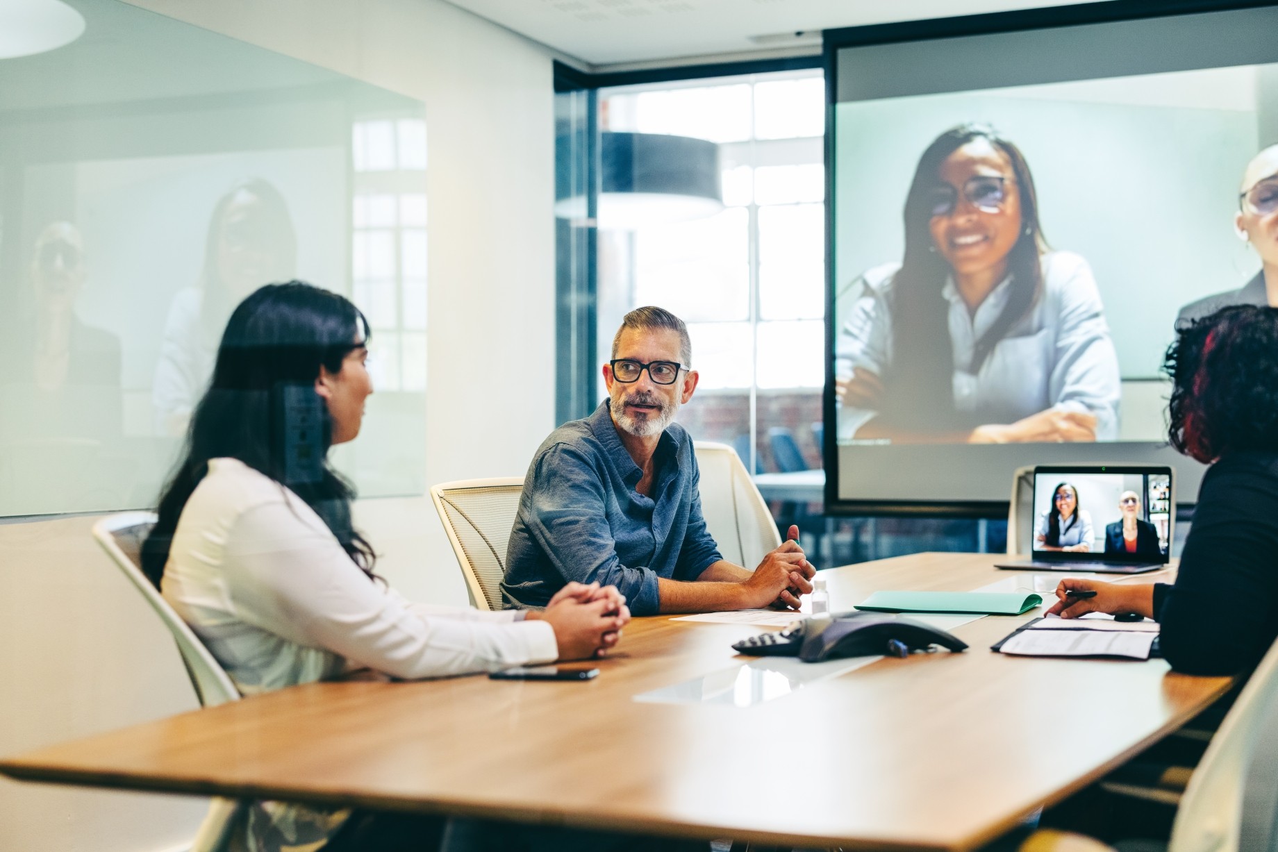 business people having a virtual meeting with their partners in a boardroom