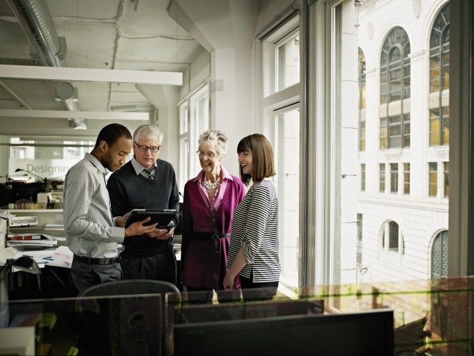 coworkers discussing project on digital tablet