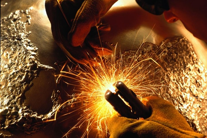 sculptor welding bronze globe