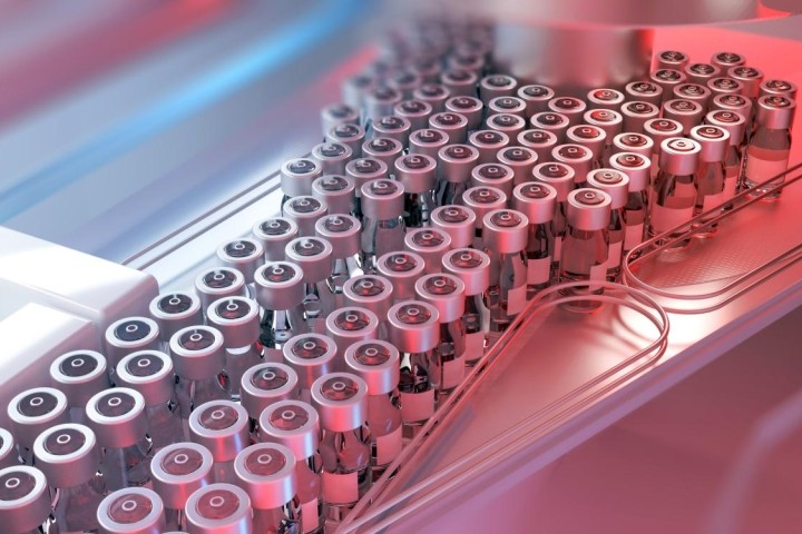 vaccine vials on assembly line with red and blue lights in background