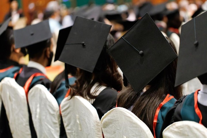 row of college graduates with caps and gowns