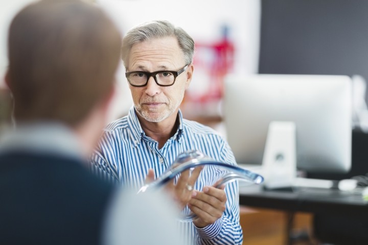 businessman explaining glass model to colleague