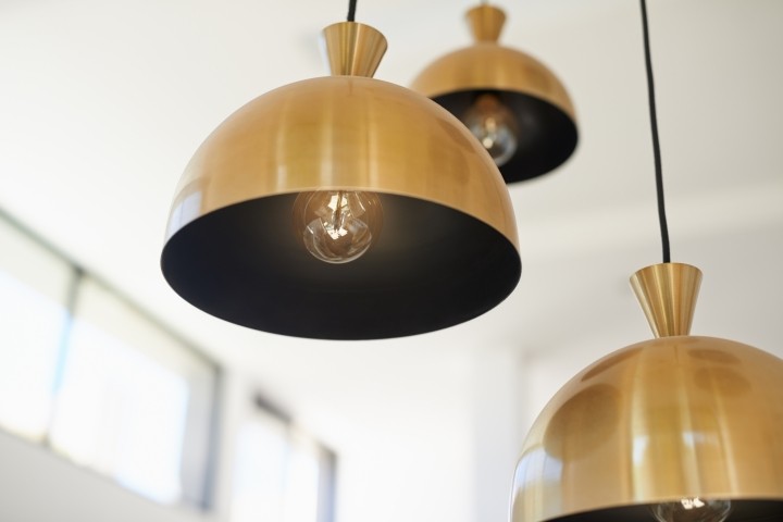 three brass pendant lights hanging at different levels