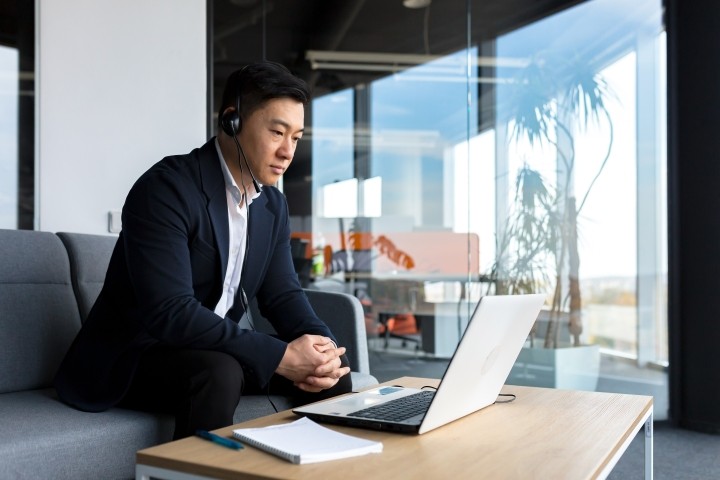 asian male executive in office on video conference