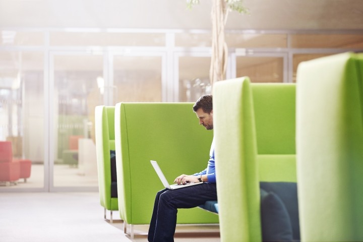 man working on laptop in lime green booth