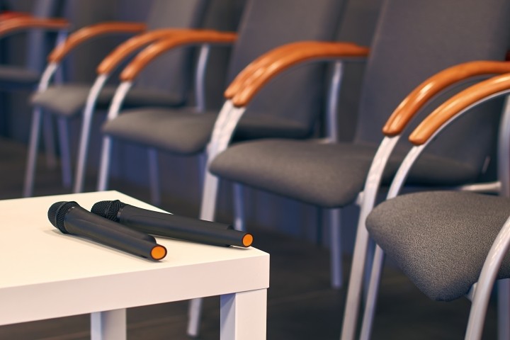 two microphones on a table with conference chairs nearby