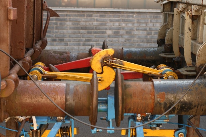 rusty railroad car buffers with components painted blue yellow and red