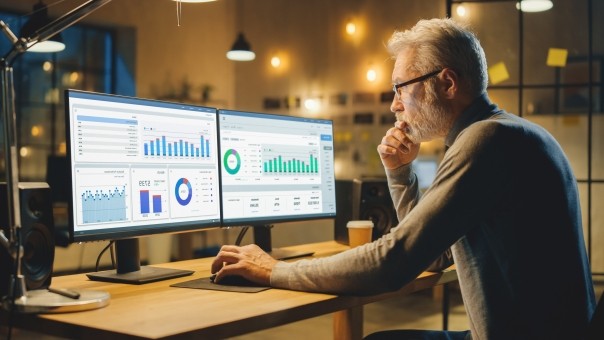 middle aged analysis works on desktop computer doing final report 