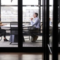 executives seated at conference table talking