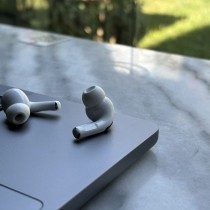 airpods resting on laptop on outside table