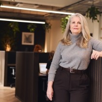 woman with long gray hair in business casual dress looking at camera