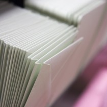 stacked envelopes on pink shelf