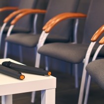 two microphones on a table with conference chairs nearby