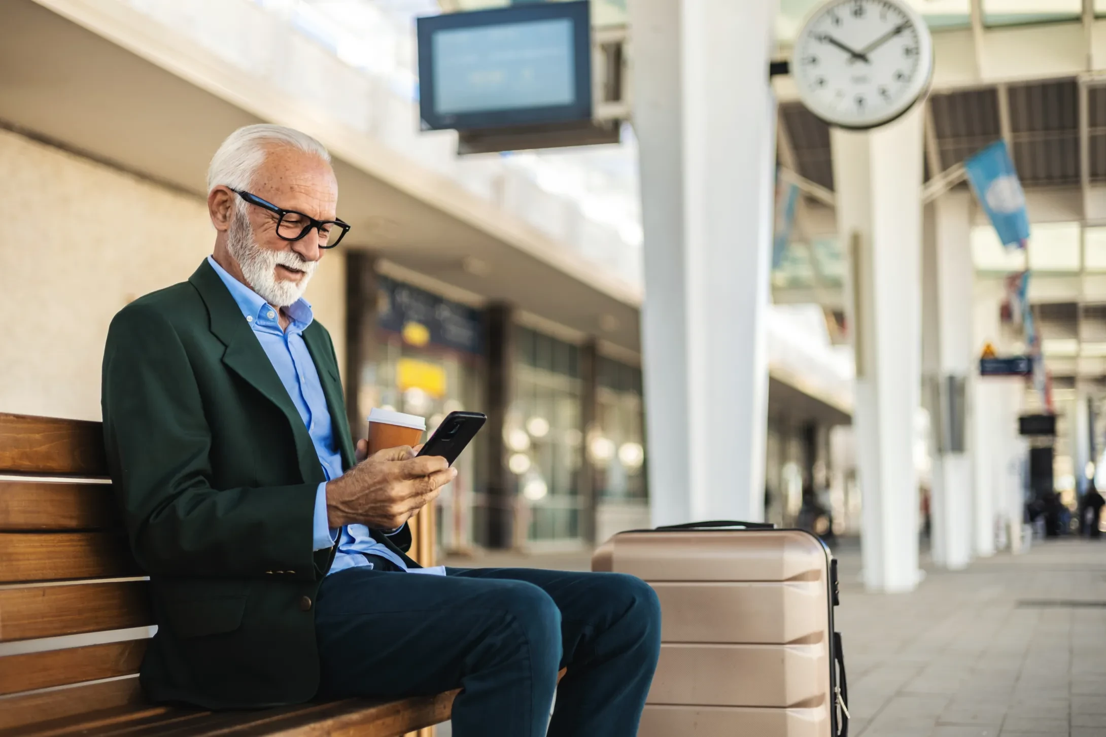 man in suit with glasses waiting outside airport